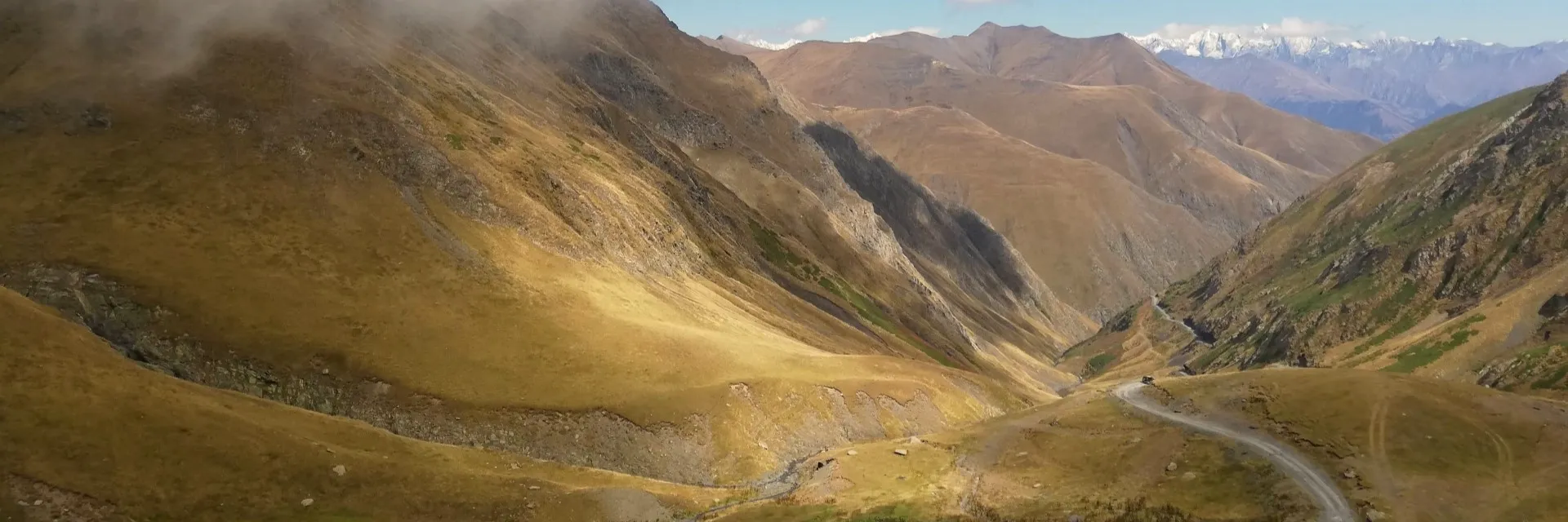 Winding dirt road through the deep valley of Abano Pass in Tusheti region