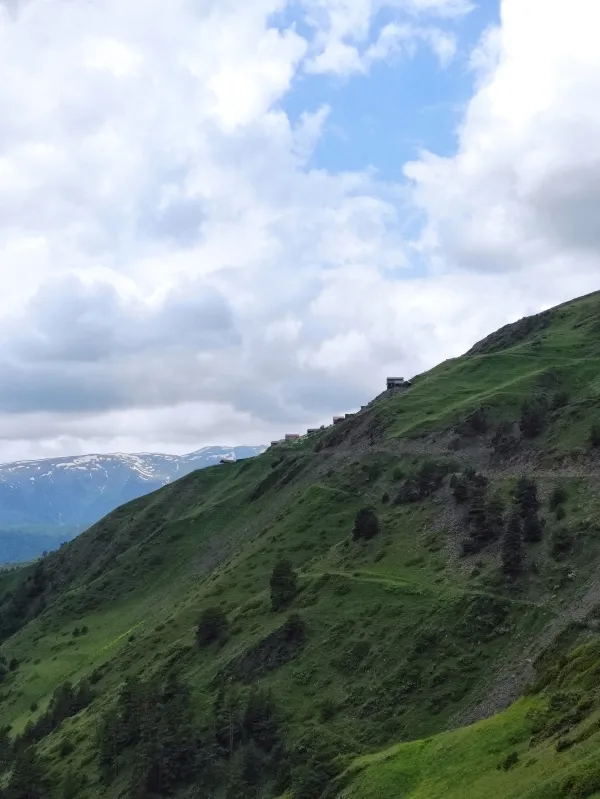 Traditional houses of Bochorna village perched on a steep green mountain ridge