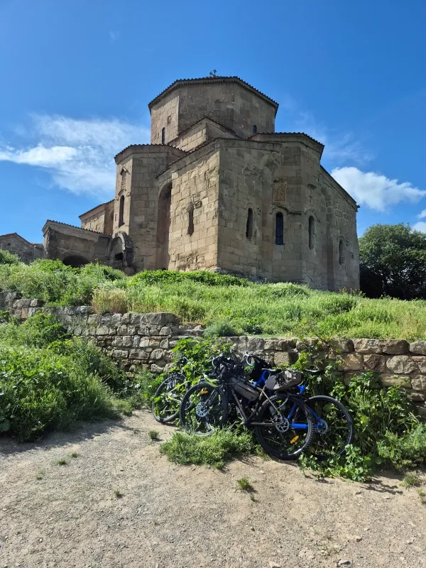 Touring bicycles parked on a trail in front of the historic Jvari Monastery