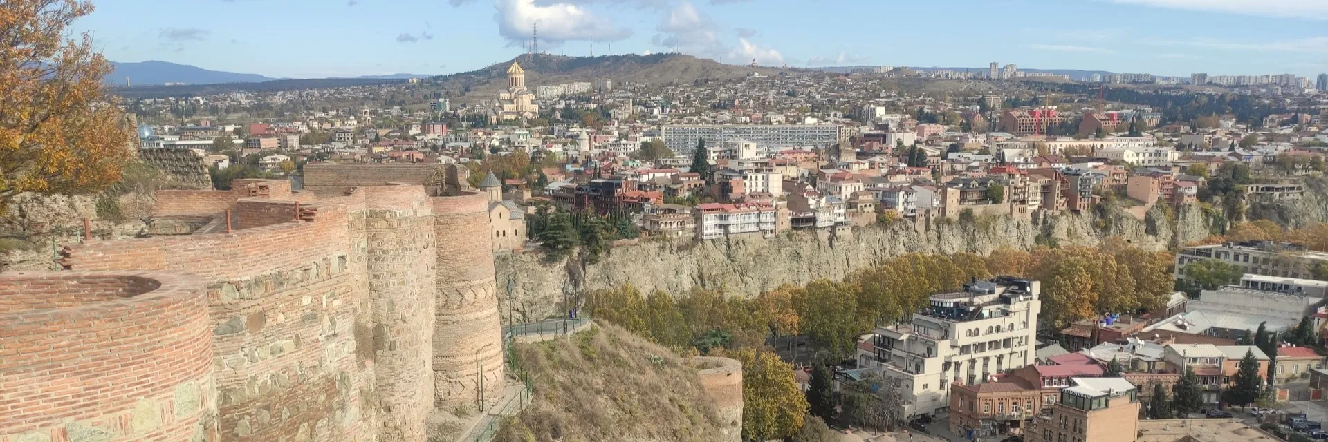 Aerial panoramic view of Narikala Fortress wall and Saint Nicholas Church overlooking Tbilisi and Mtkvari River