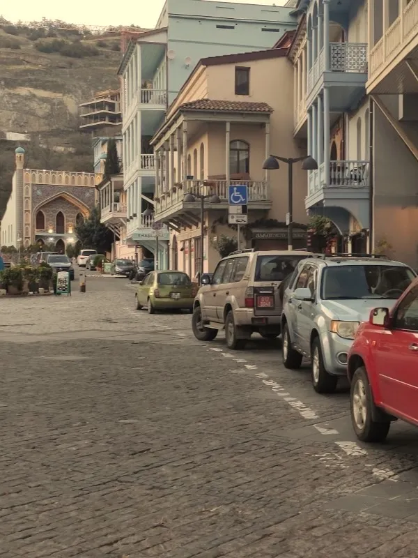 A cobblestone street in the historic Abanotubani district featuring the iconic Orbeliani Sulfur Baths Tbilisi