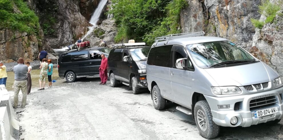 4WD off-road vehicles and travelers on a rugged mountain road during a 3-day Tusheti jeep tour.