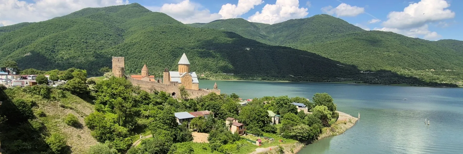 Scenic aerial view of Ananuri Fortress complex overlooking turquoise Jinvali Reservoir on the Georgian Military Highway