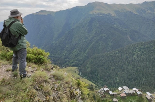 Traveler photographing a remote traditional village in Gometsari Valley, Tusheti Georgia