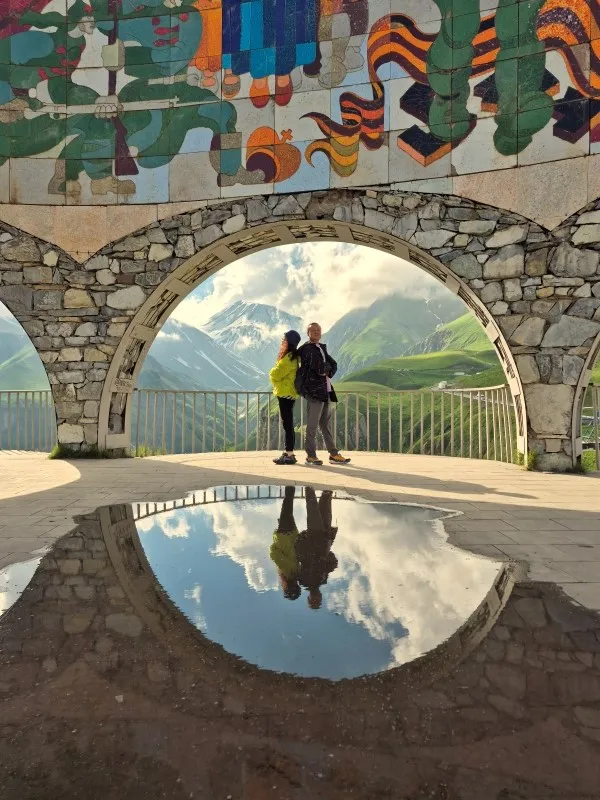 Artistic reflection of colorful Soviet mosaic arch and mountains at Gudauri Panorama