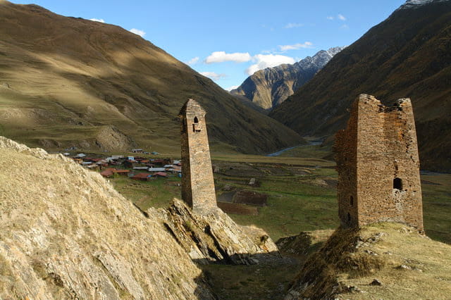 Historic defensive stone towers overlooking a mountain village in Pirikiti Valley, Tusheti